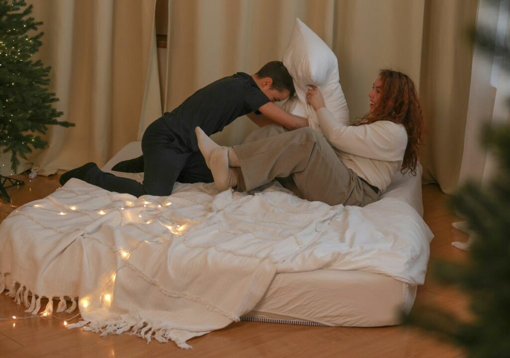 couple qui joue à un bataille de coussin, un moment de joie spontané qui laissent des souvenirs.