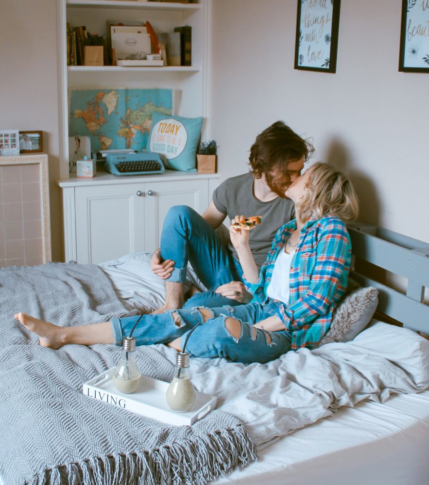 Couple qui prend son petit déjeuner au lit, créant des souvenirs inoubliables.